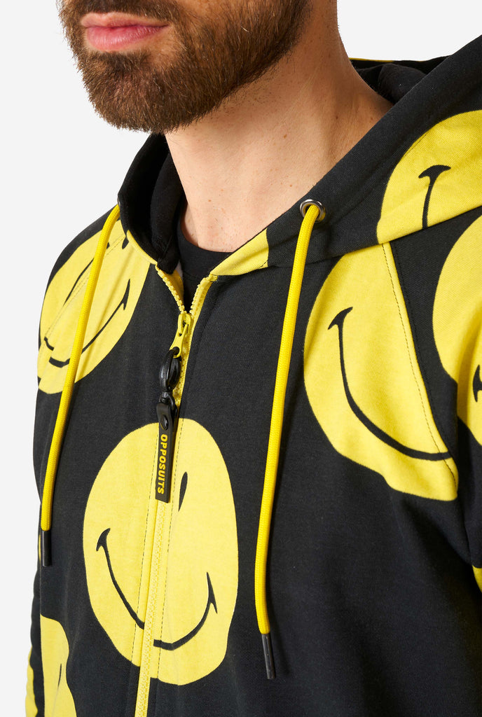 Man wearing black onesie with yellow smiley print, chest close up