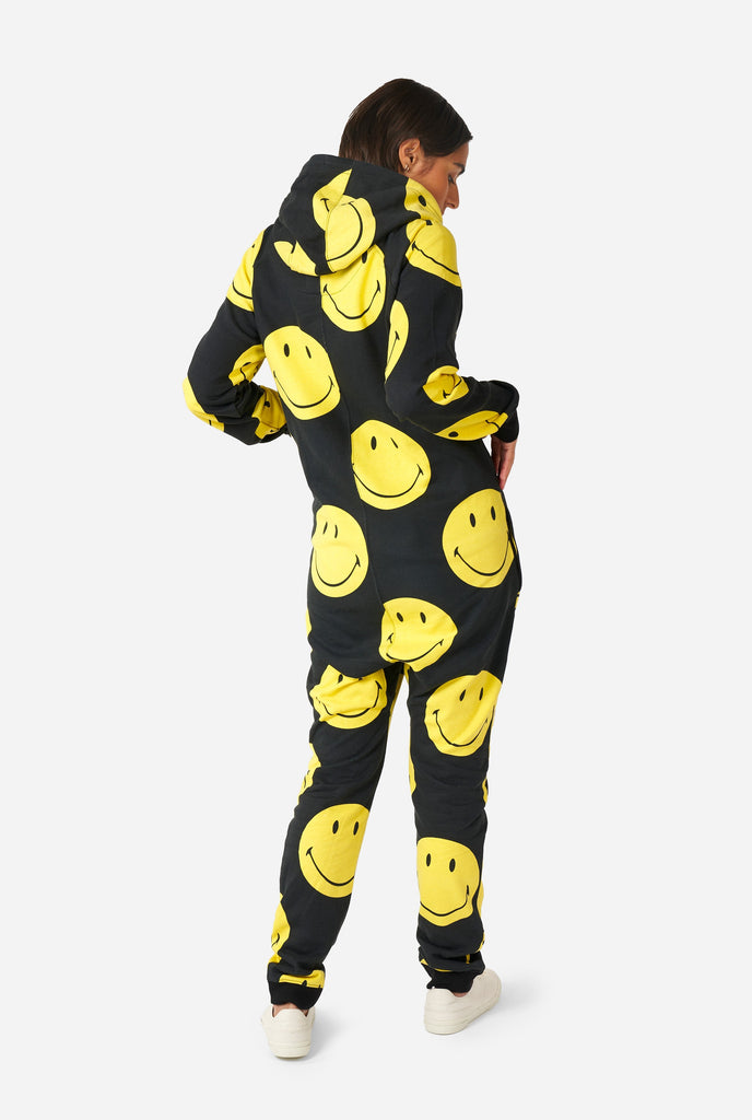 Woman wearing black onesie with yellow smiley print, view from the back