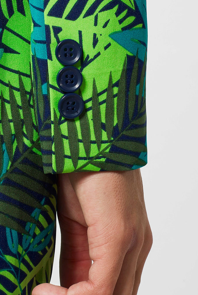 Woman wearing suit with green jungle leaves print, sleeve close up