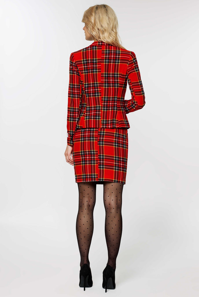 Woman wearing red tartan Christmas suit, view from the back